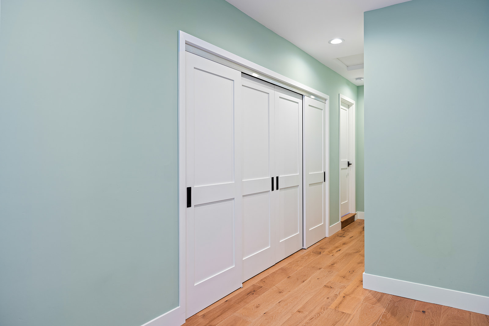 Interior doors and oak flooring Hallway remodel with new interior sliding doors, sage green paint, and white oak flooring