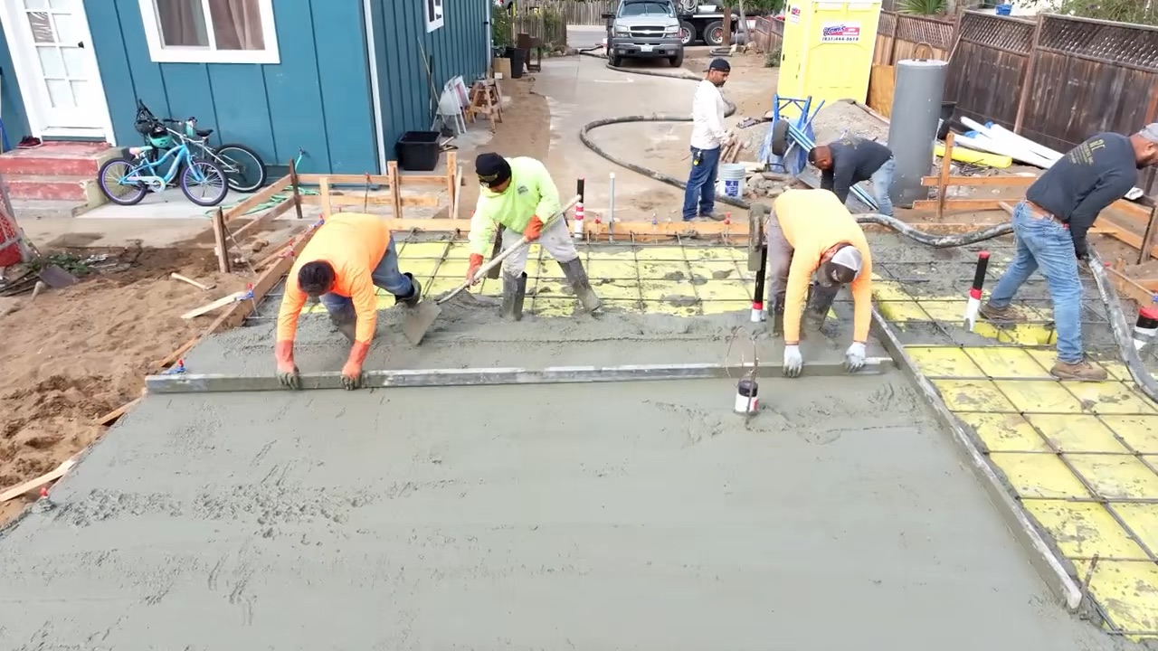 Concrete slab finishing RC Builders crew screeding and finishing a freshly poured concrete slab